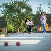 Two Women Drinking Wine and Playing Bocce