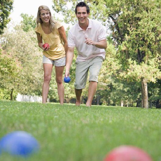Man and Woman Outside Playing Bocce Ball