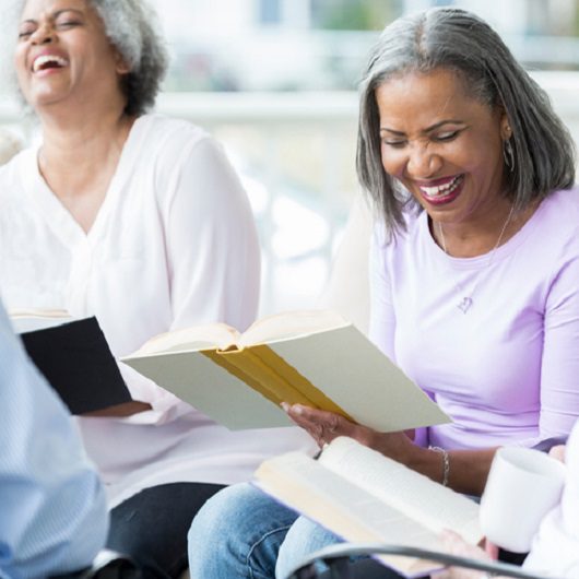 Two women reading books and laughing, in Ave Maria Florida