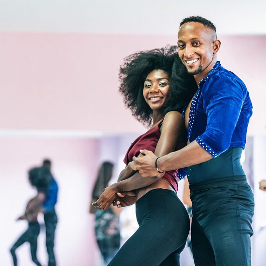 Couple dancers practicing in studio, holding hands