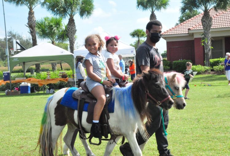 Two young girls each riding a pony