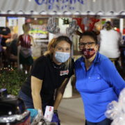 Two women smiling at tent