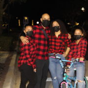 Family of four posing with decorated bike