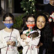 Two young girls with masks with mom and pet