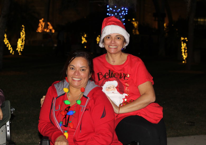 Two women in Christmas outfits smiling