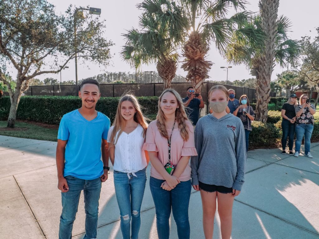 Four young teenagers standing and smiling