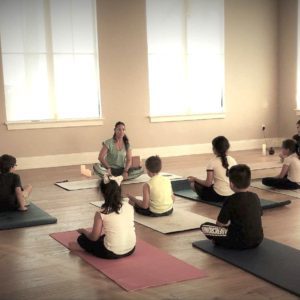 A group of kids sitting on Yoga mats