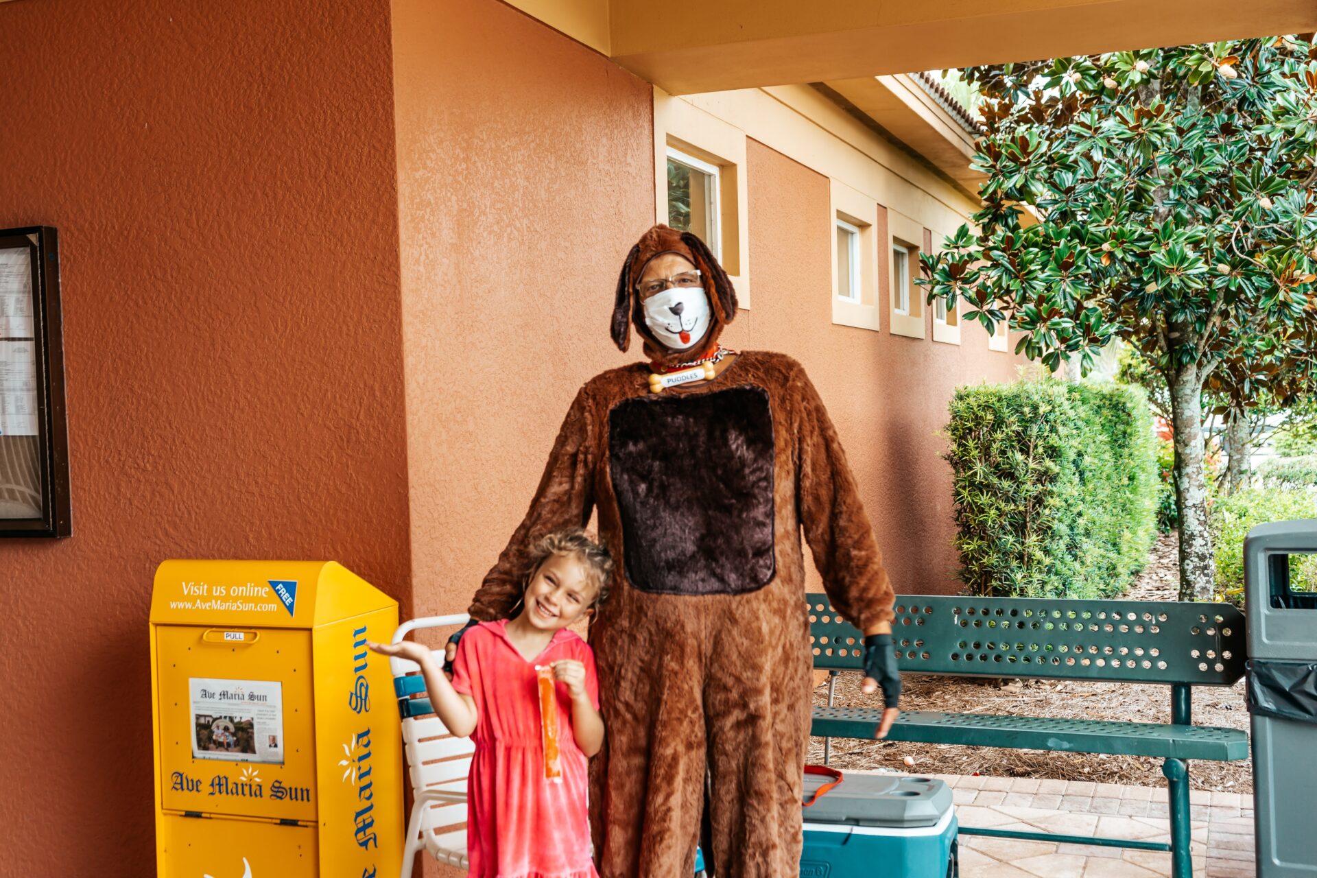 Young girl standing next to dog character