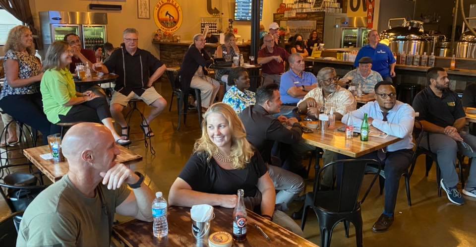 Group of people sitting, smiling inside bar in Ave Maria