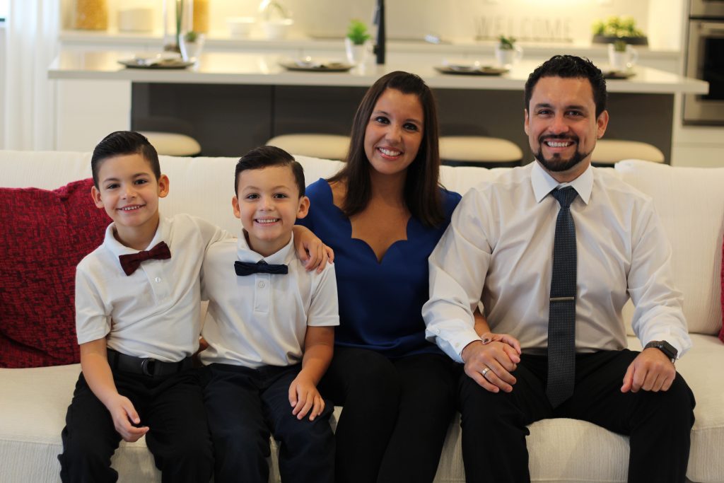 Two adults and two children sitting on couch in Maple Ridge Home by CCHomes