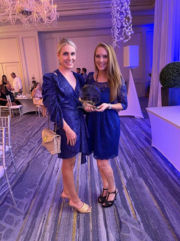 Two woman standing holding award for Ave Maria, Florida