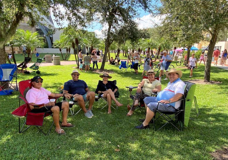 Friends sitting in chairs on lawn at event in Ave Maria Florida
