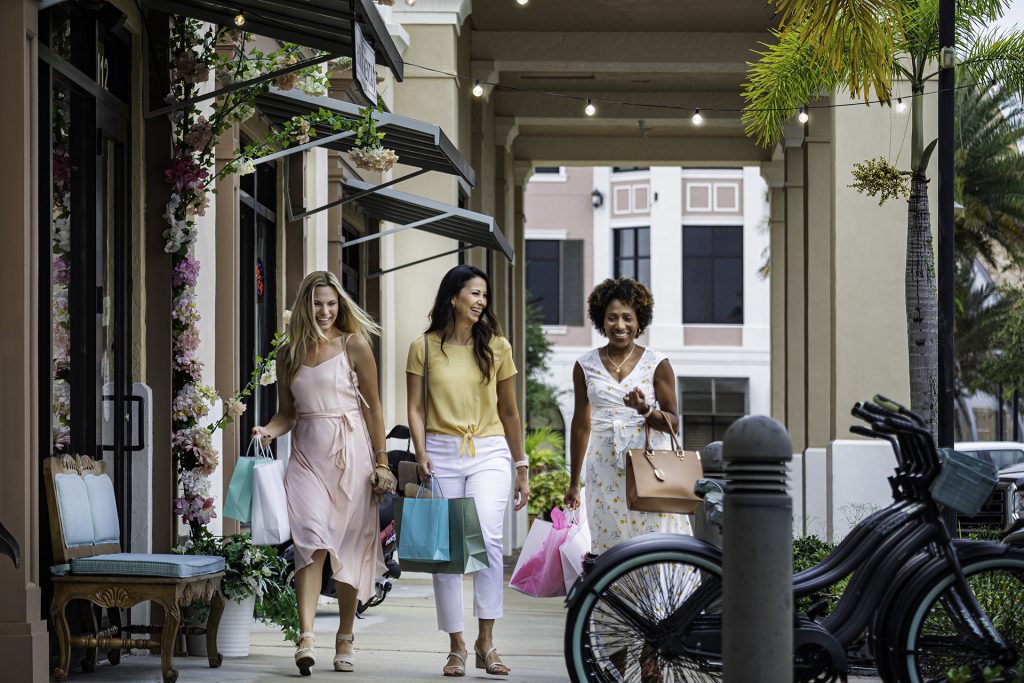Three women walking with shopping bags in Ave Maria Florida