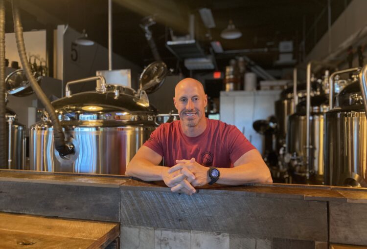 Matt stands in front of his beer distillery