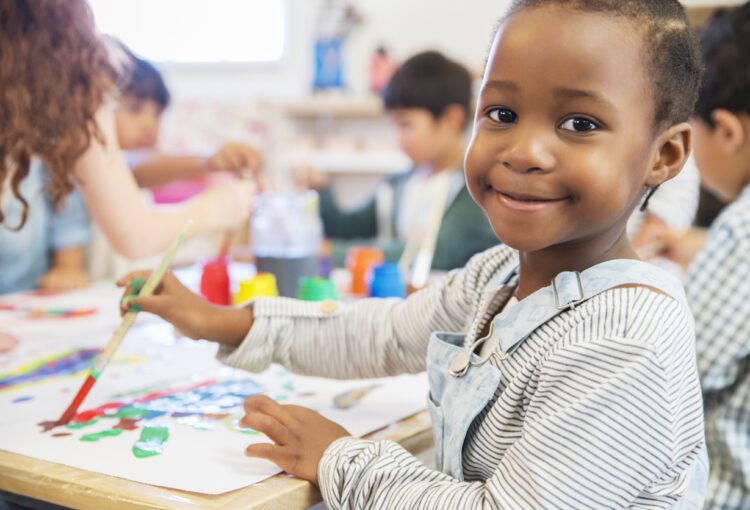 Preschooler smiles while painting