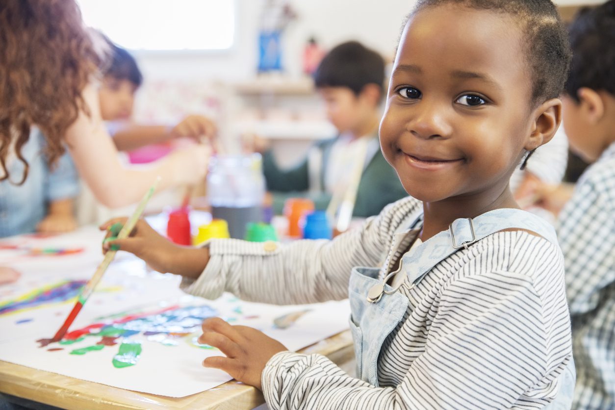 Preschooler smiles while painting