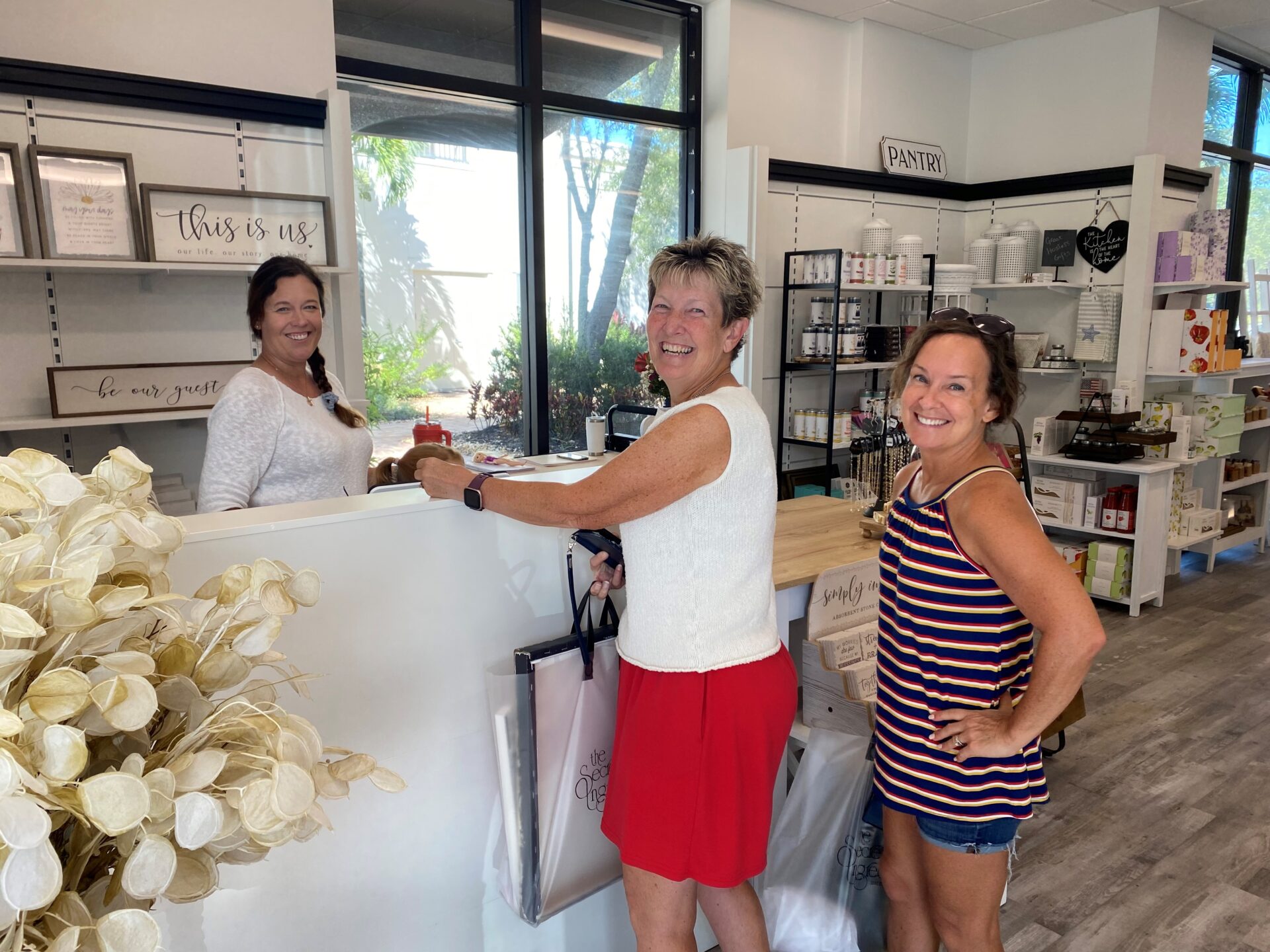 Three women smiling at the checkout counter