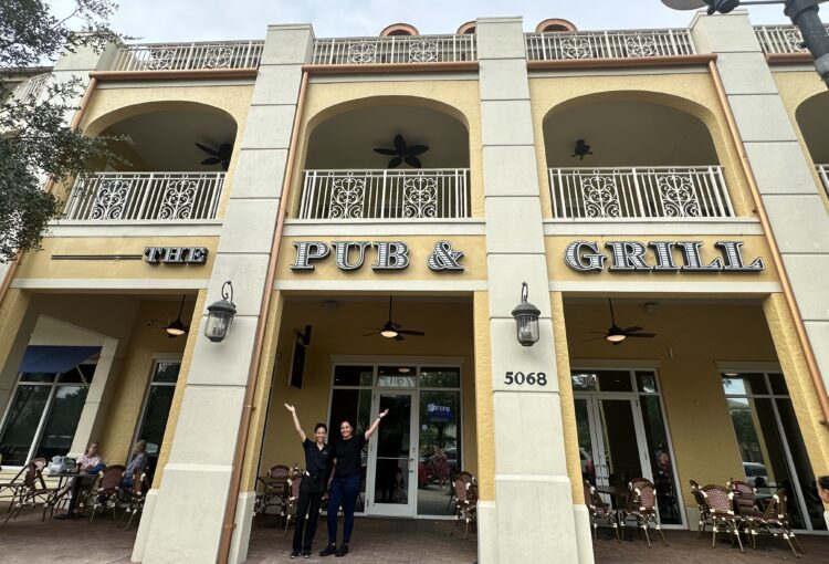 The Pub & Grill at Ave Maria front elevation with two servers at the entrance