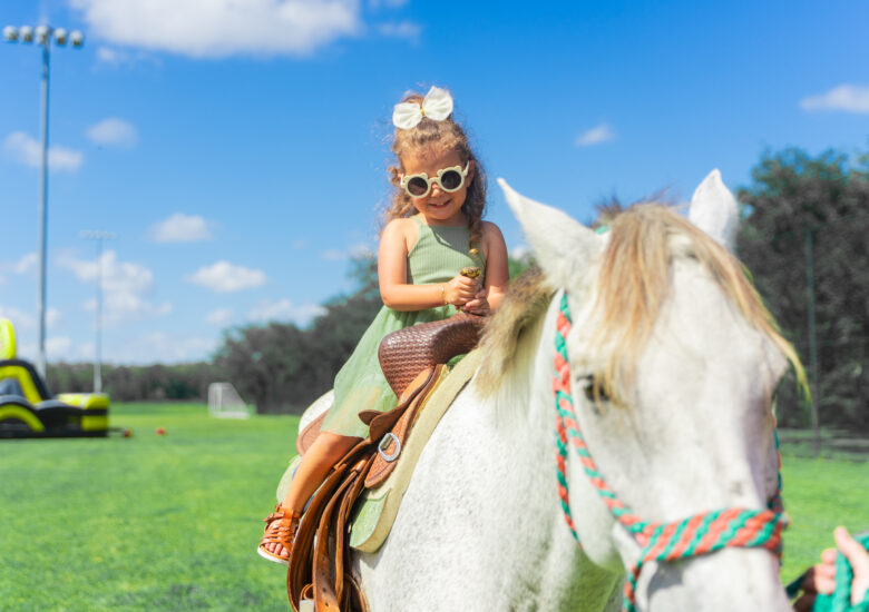 Little girl rides horse at the 2023 Ave Maria Fall Festival