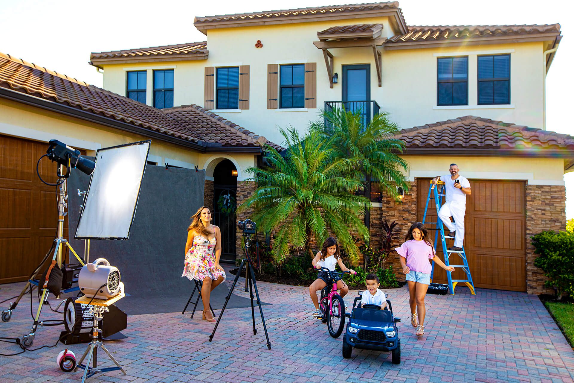 Family in driveway playing and posing for a photo