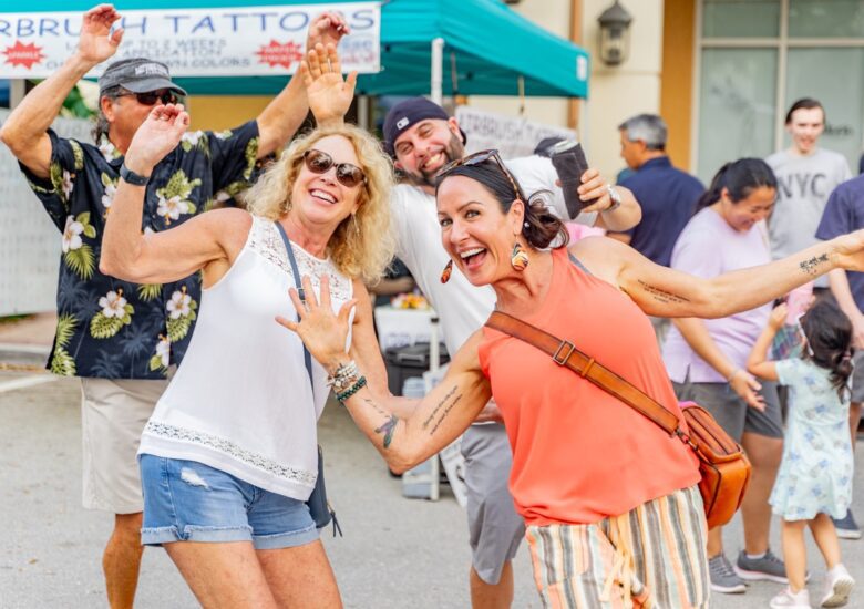 Friends wave at camera while attending the 2024 Blues, Brews & BBQ Festival in Ave Maria