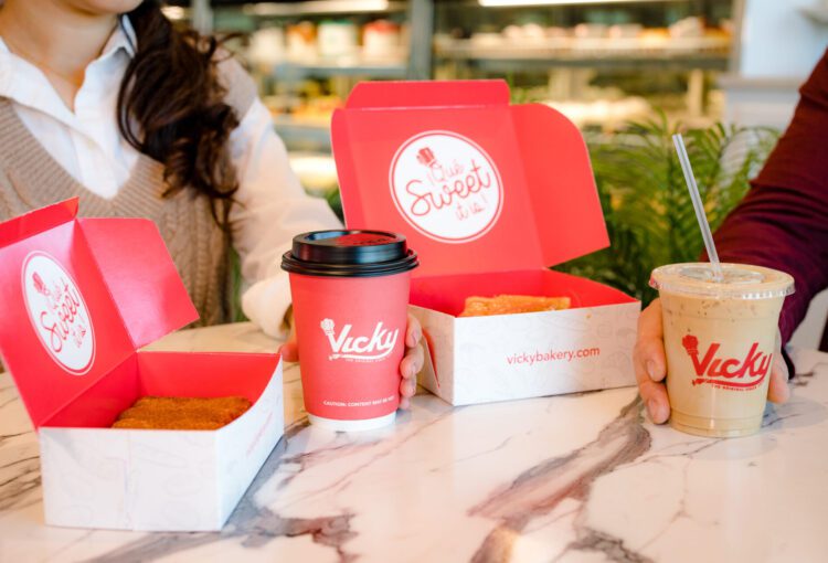 Vicky Bakery menu items displayed on counter with patrons holding food products