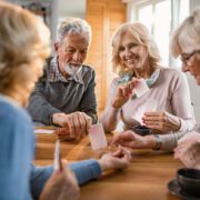 Happy seniors having fun while playing card game at home.